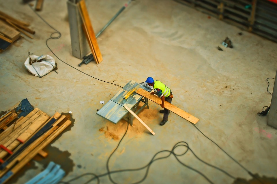 Construction worker cutting wood