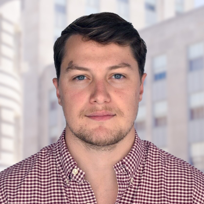 Headshot of Zakk Rhine in front of buildings