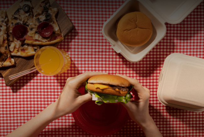 Person enjoying a picnic at a table covered in food